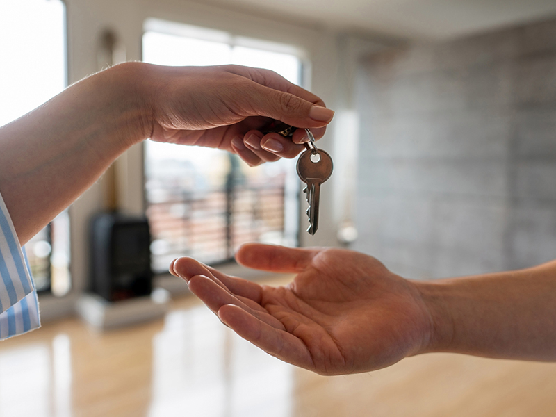 Real estate agent giving the keys of his new house to a man